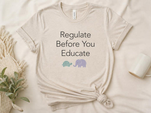 Heather sand adult tee printed with Regulate Before You Educate and a turtle and elephant
